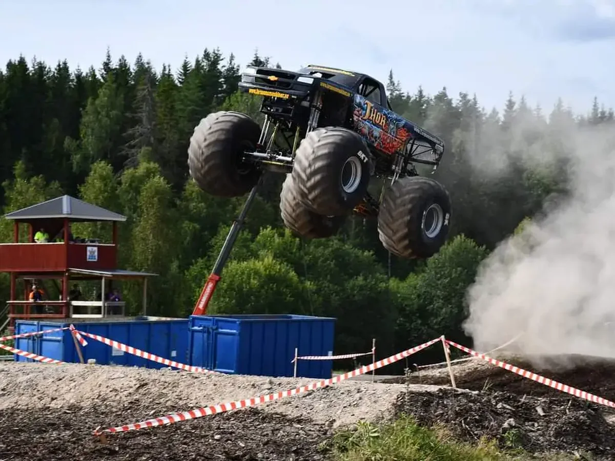 Monstertruck under hopp i bullrig motorsportmiljö